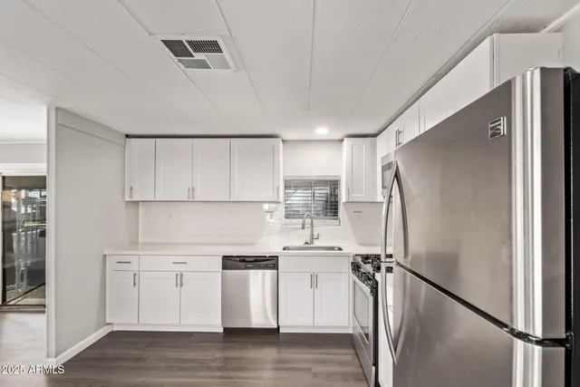 a kitchen with white cabinets and white stainless steel appliances