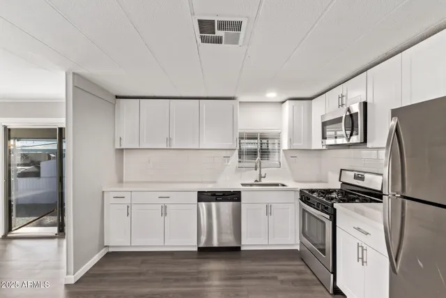 a kitchen with stainless steel appliances a refrigerator sink and stove