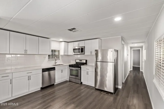 a kitchen with a refrigerator sink and cabinets