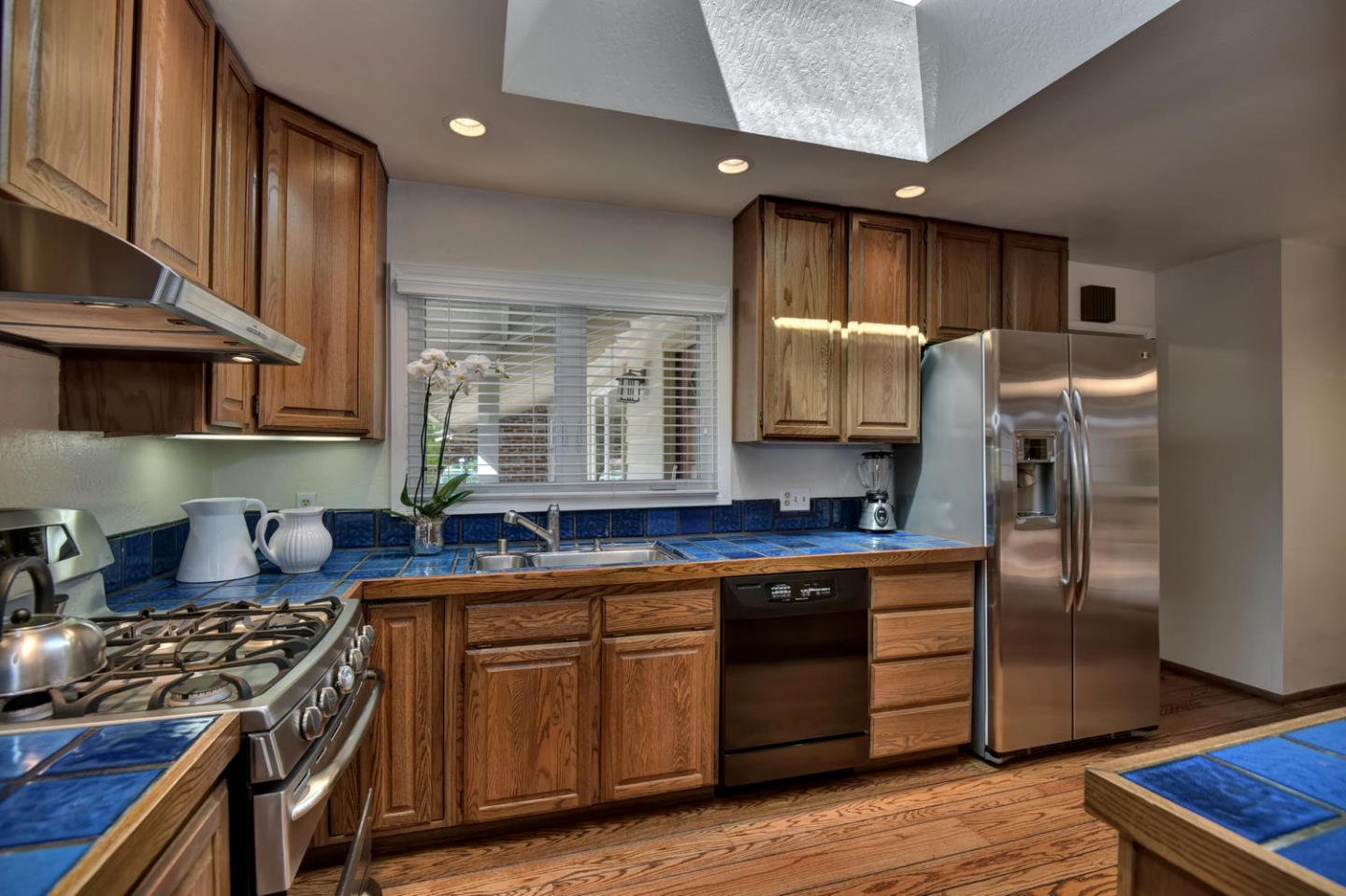 12338 Brookglen Drive Saratoga, CA 95070 - Photo 5 of 18 a kitchen with kitchen island granite countertop a sink cabinets and stainless steel appliances