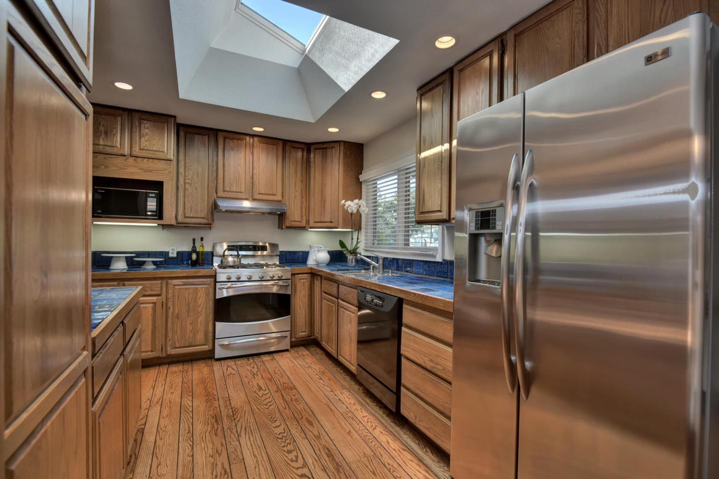 12338 Brookglen Drive Saratoga, CA 95070 - Photo 9 of 18 a kitchen with kitchen island granite countertop stainless steel appliances cabinets a sink and a counter top space