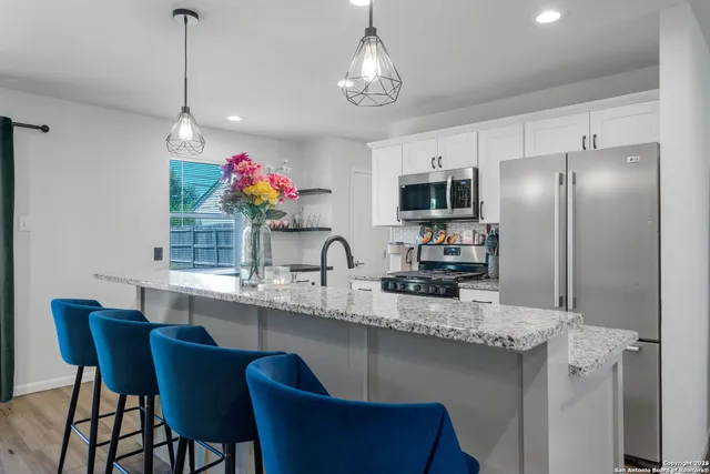 a kitchen with stainless steel appliances granite countertop a sink refrigerator and microwave