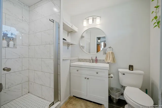 a bathroom with a toilet a sink and mirror