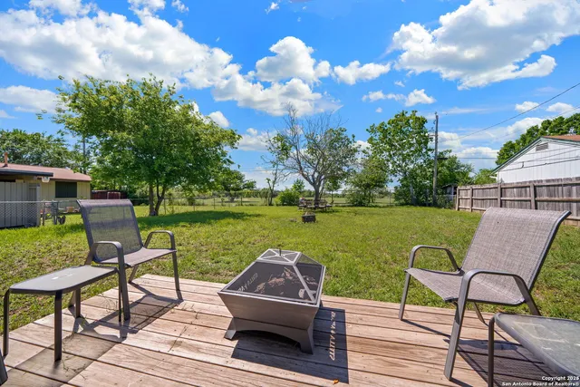 a view of a lake with table and chairs under an umbrella