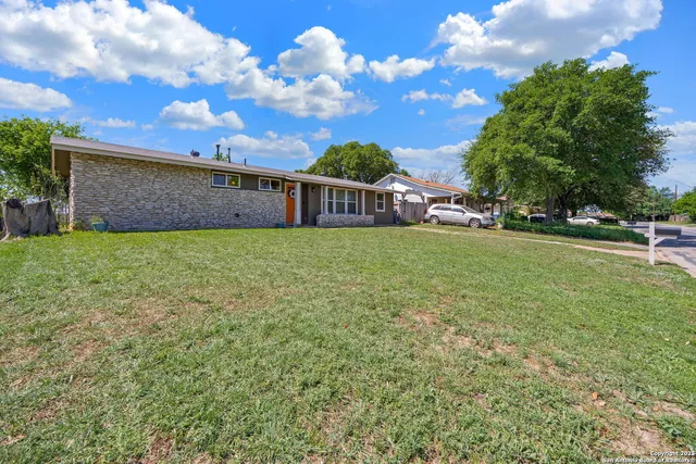 a view of a house with a yard and sitting area