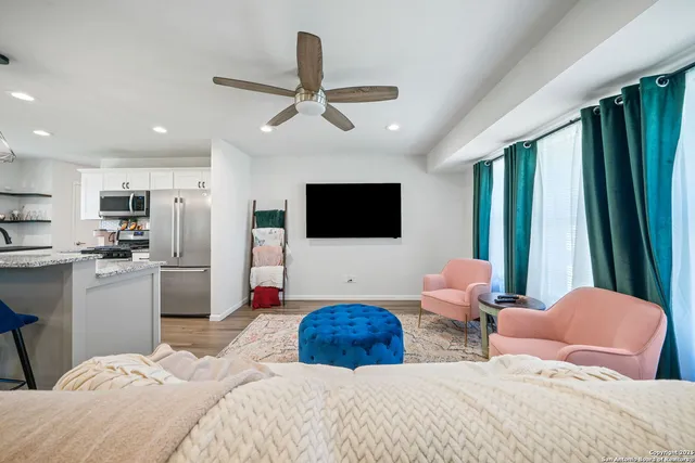a bedroom with a bed a window and a flat screen television