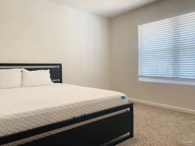 a bedroom with a bed and window