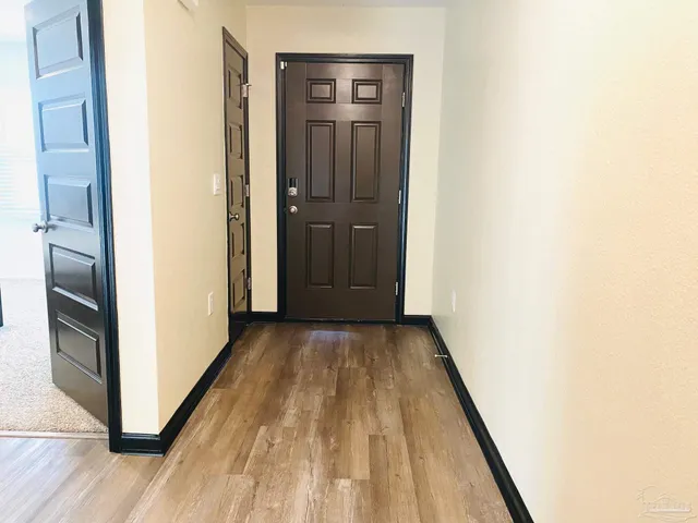 a view of a hallway with wooden floor