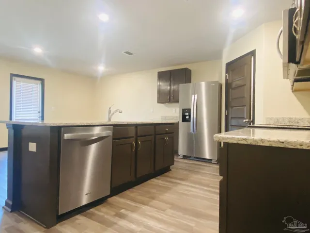 a kitchen with stainless steel appliances a refrigerator and a stove