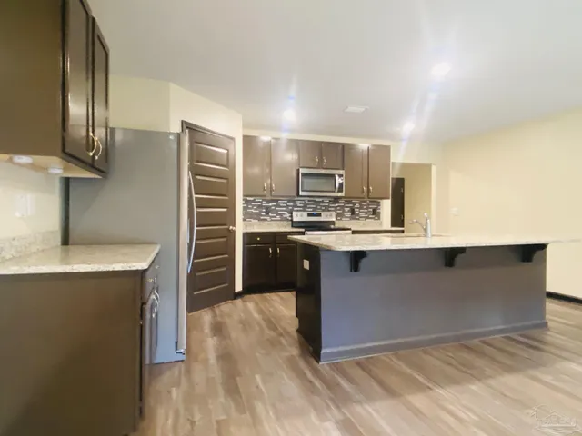 a kitchen with stainless steel appliances granite countertop a stove a sink and a refrigerator