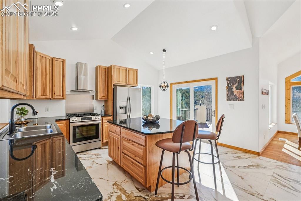 507 Yorktown Road Cripple Creek, CO 80813 - Photo 17 of 50 a kitchen with stainless steel appliances granite countertop a stove top oven a sink a dining table and chairs with wooden floor