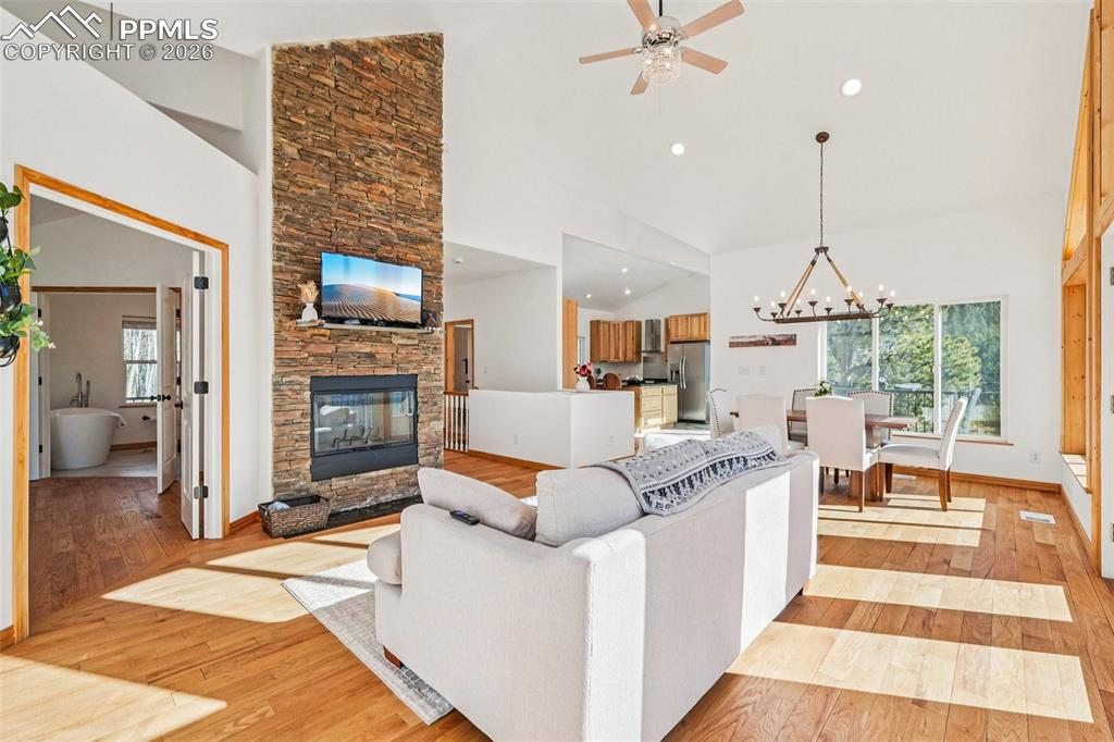 507 Yorktown Road Cripple Creek, CO 80813 - Photo 8 of 50 a living room with furniture a fireplace and a chandelier