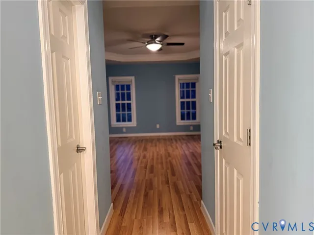 an entryway to room with wooden floor and fan