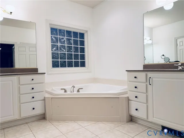 a bathroom with a bathtub sink and mirror