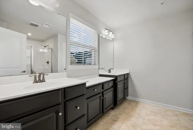 a bathroom with double sink and a mirror