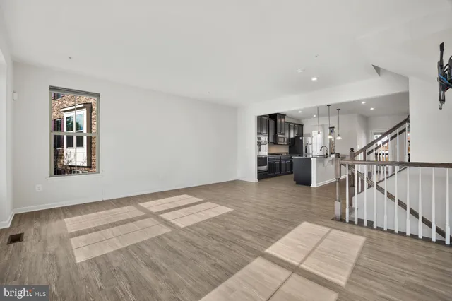 a view of empty room with wooden floor and windows