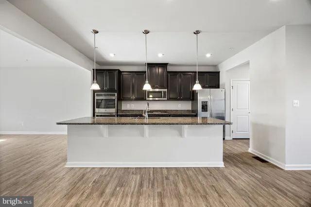 a view of kitchen with refrigerator microwave and wooden floor