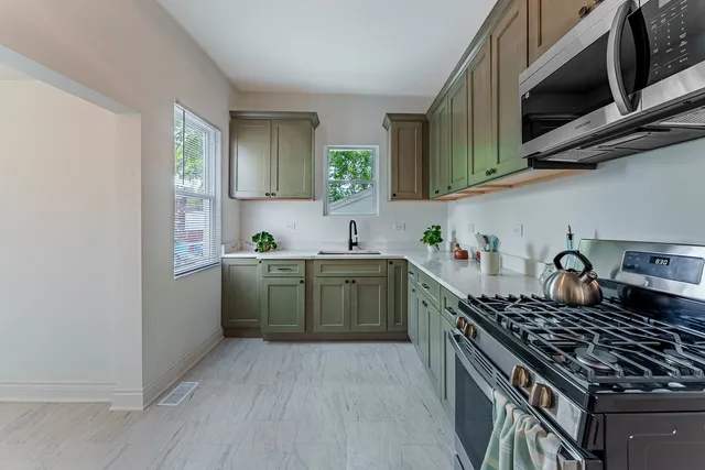 a kitchen with a sink a stove and cabinets