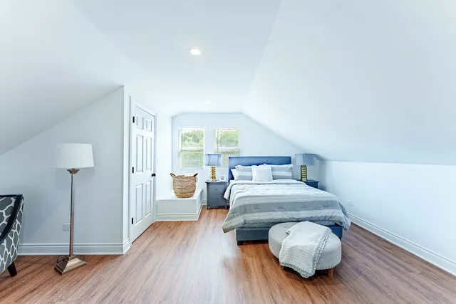 a bedroom with a bed and wooden floor