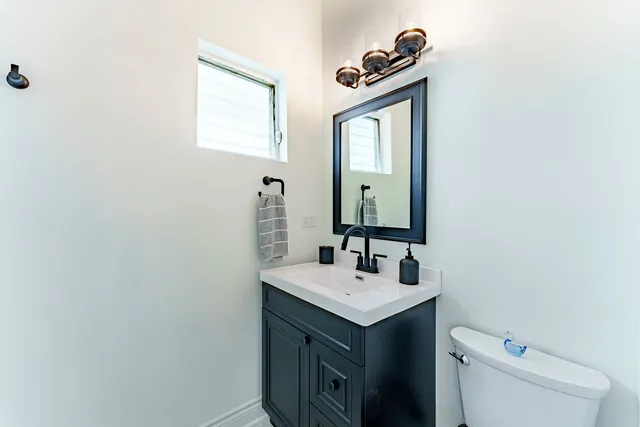 a bathroom with a sink a toilet and mirror