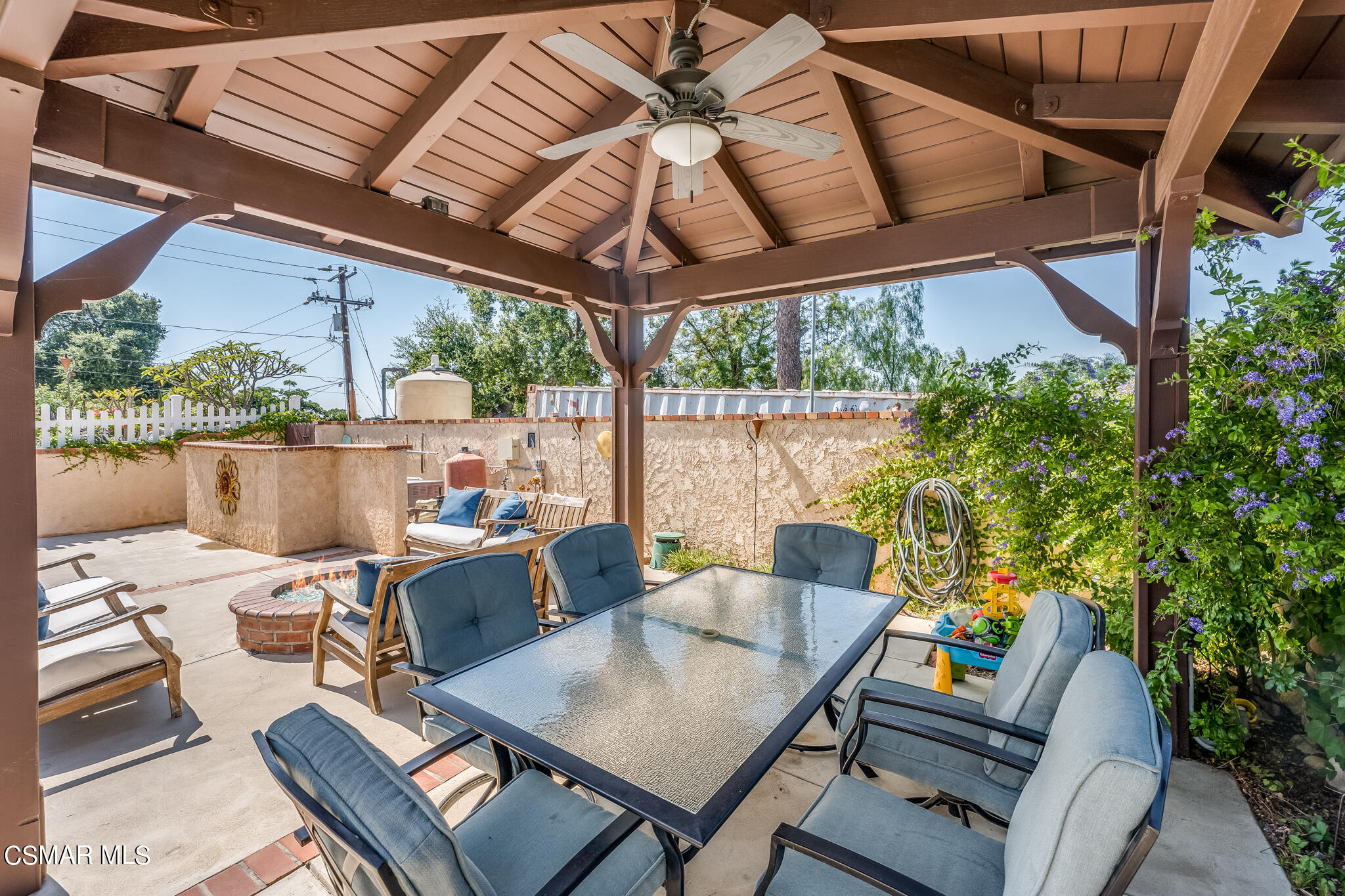5765 Oak Knolls Road Simi Valley, CA 93063 - Photo 67 of 71 a view of a patio with a table and chairs under an umbrella with a small yard