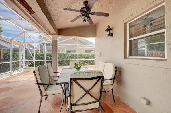 a living room with patio furniture and a chandelier