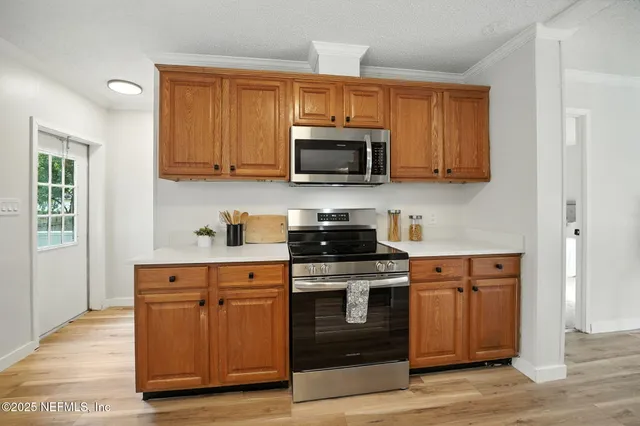 a kitchen with stainless steel appliances granite countertop a stove a sink and a microwave