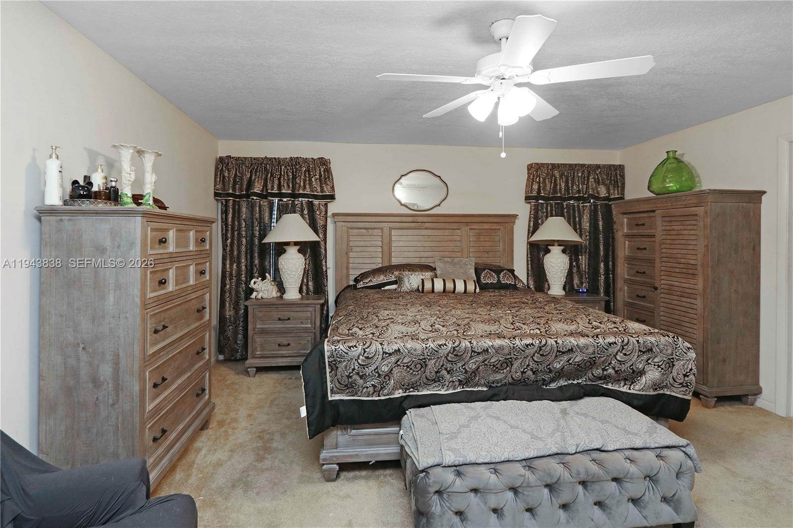13243 Southwest 258th Terrace Homestead, FL 33032 - Photo 13 of 25 a bedroom with a bed and a chandelier