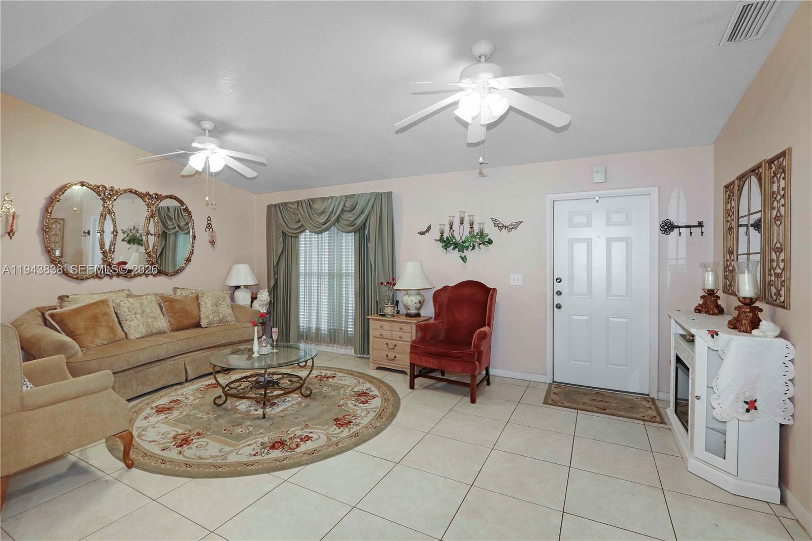 13243 Southwest 258th Terrace Homestead, FL 33032 - Photo 4 of 25 a living room with furniture a chandelier and a window