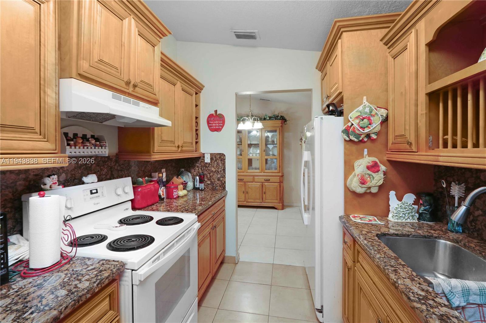 13243 Southwest 258th Terrace Homestead, FL 33032 - Photo 10 of 25 a kitchen with a sink stove and cabinets