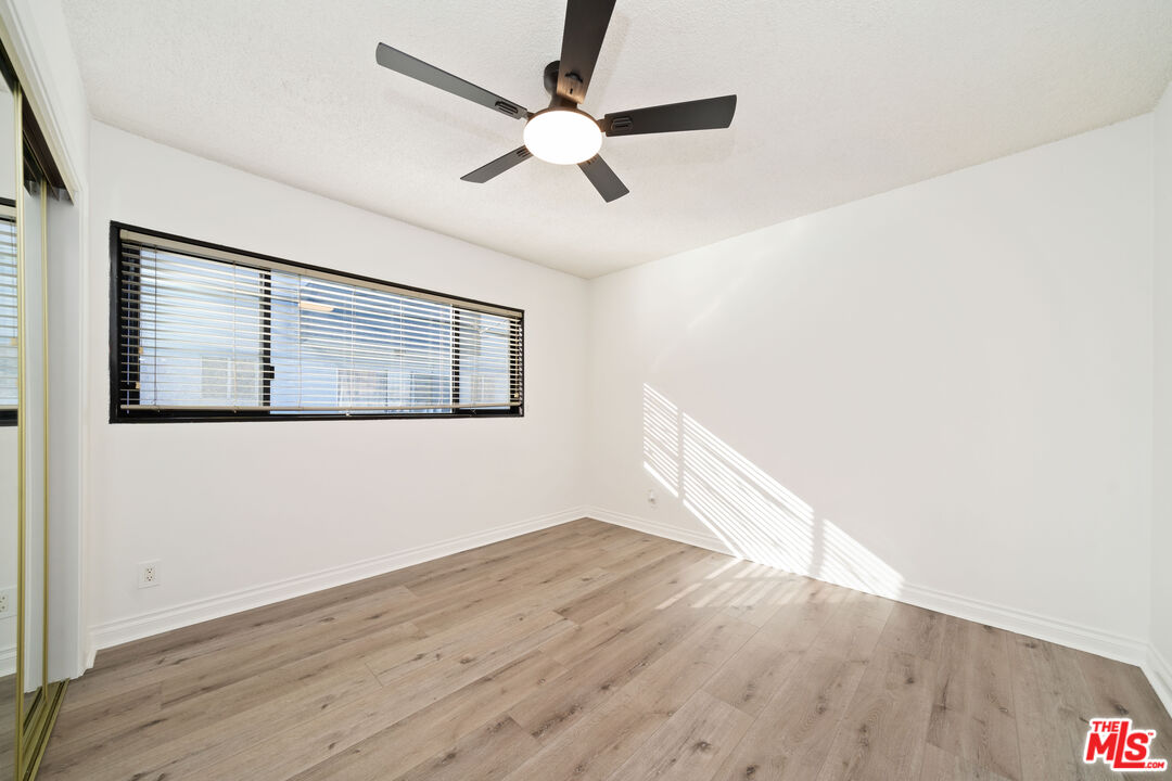 8933 Cadillac Avenue, Unit 4 Los Angeles, CA 90034 - Photo 12 of 17 an empty room with wooden floor fan and windows