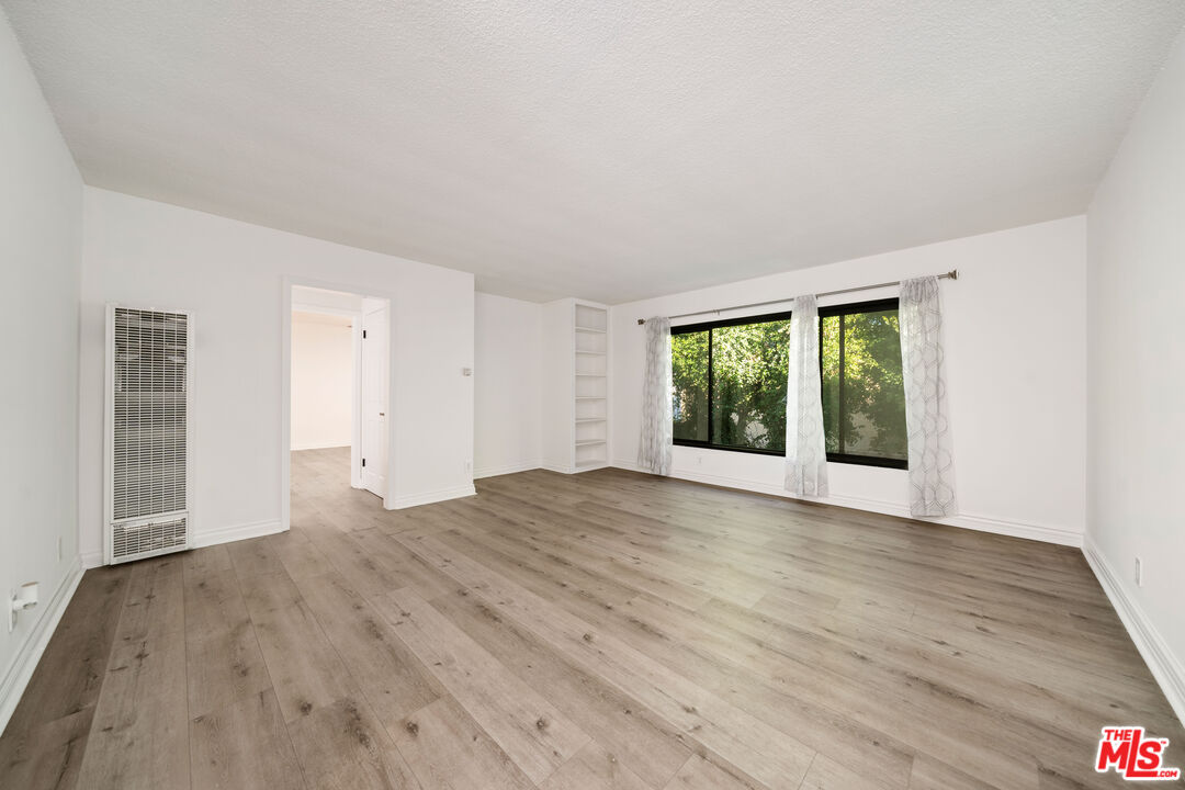 8933 Cadillac Avenue, Unit 4 Los Angeles, CA 90034 - Photo 3 of 17 a view of an empty room with wooden floor and a window