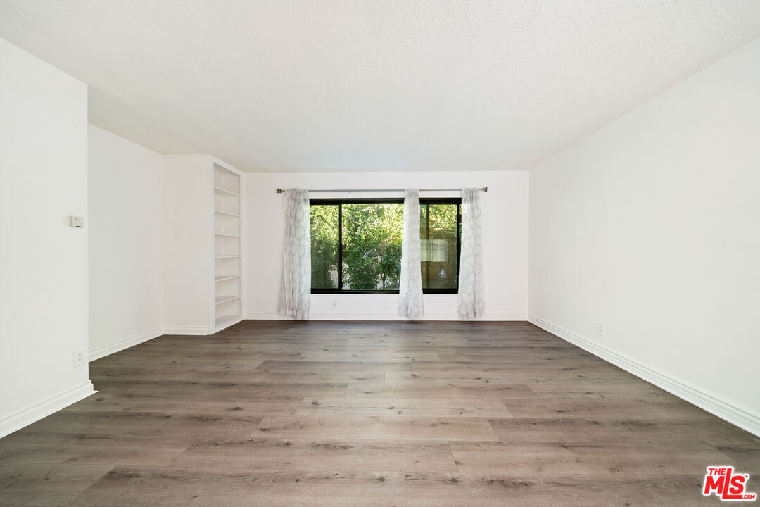 8933 Cadillac Avenue, Unit 4 Los Angeles, CA 90034 - Photo 4 of 17 a view of an empty room with wooden floor and a window