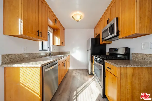 a kitchen with stainless steel appliances granite countertop a sink and a stove