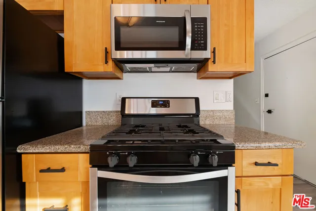 a kitchen with stainless steel appliances granite countertop a stove and a microwave