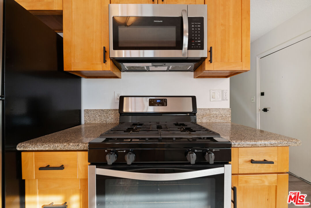 8933 Cadillac Avenue, Unit 4 Los Angeles, CA 90034 - Photo 9 of 17 a kitchen with stainless steel appliances granite countertop a stove and a microwave