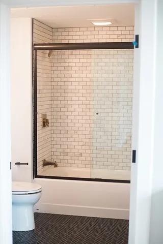 a bathroom with a toilet and a shower
