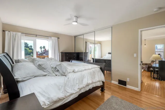 a bedroom with a large bed and wooden floor