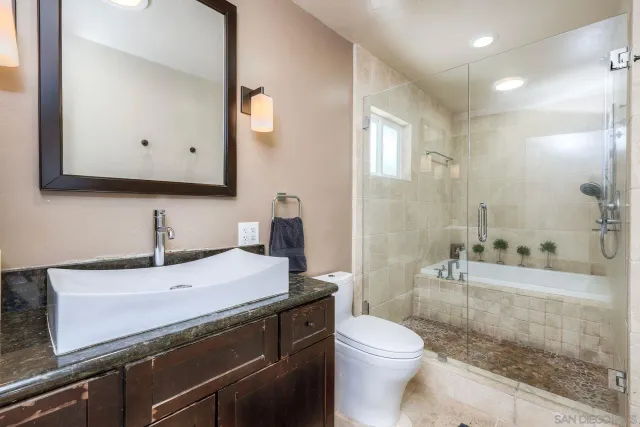 a bathroom with a sink a toilet and shower