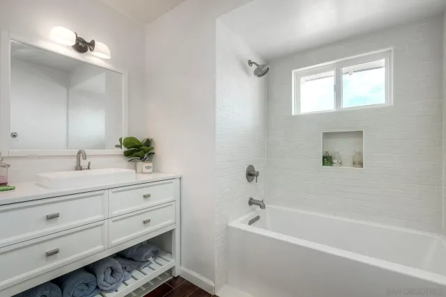 a bathroom with a bathtub shower sink and mirror