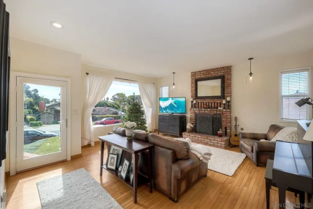 a living room with fireplace furniture and a large window