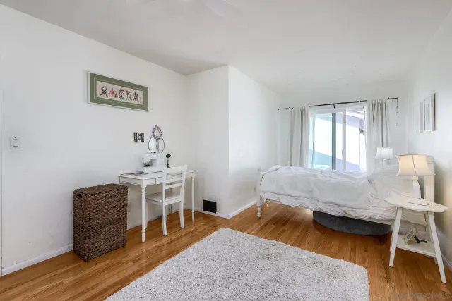 a bedroom with furniture and a wooden floor