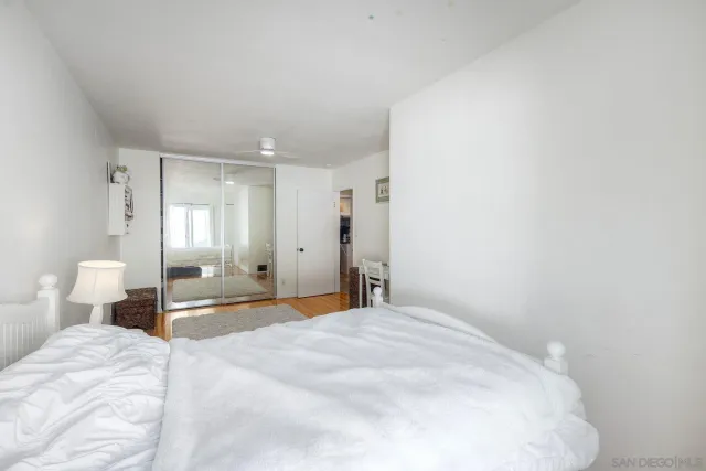 a spacious bedroom with a bed and a lamp