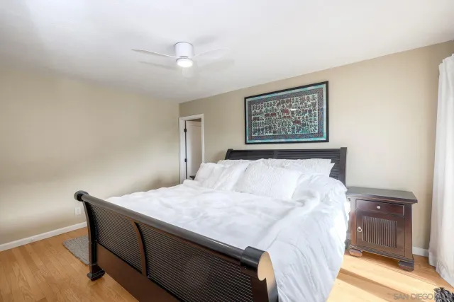 a bedroom with a bed and a painting on the wall