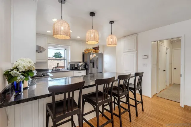 a dining room filled chandelier and wooden floor