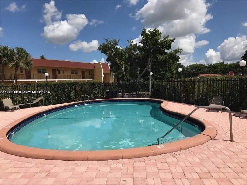 7920 North Colony Circle, Unit 107 Tamarac, FL 33321 - Photo 10 of 11 a view of a swimming pool with a yard