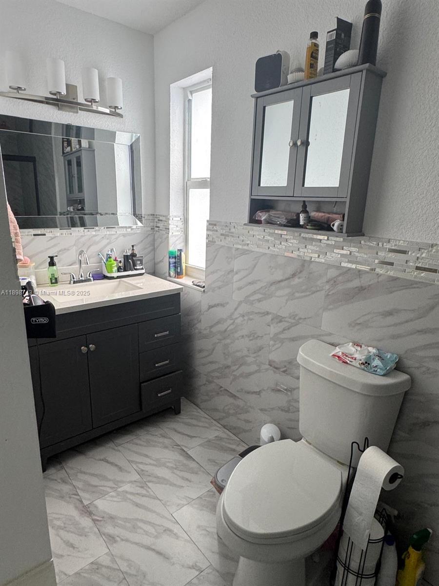 12100 Southwest 271st Street, Unit 12100 Homestead, FL 33032 - Photo 14 of 24 a bathroom with a toilet sink and mirror