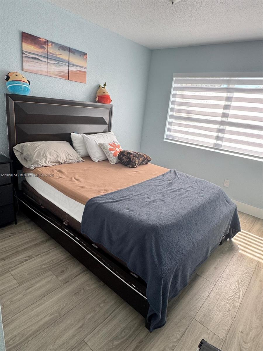 12100 Southwest 271st Street, Unit 12100 Homestead, FL 33032 - Photo 17 of 24 a bedroom with a bed and window