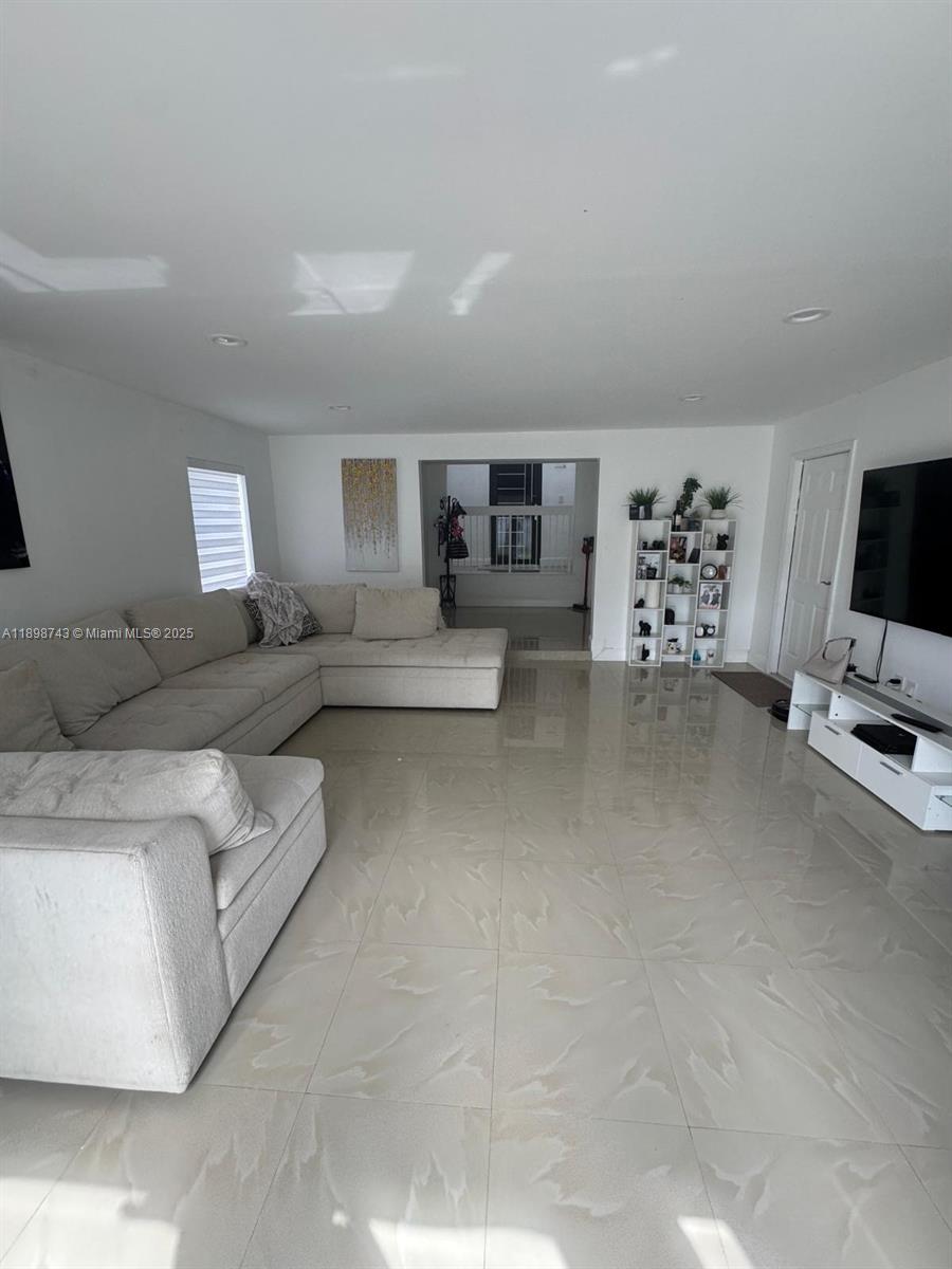 12100 Southwest 271st Street, Unit 12100 Homestead, FL 33032 - Photo 2 of 24 a living room with furniture and a flat screen tv