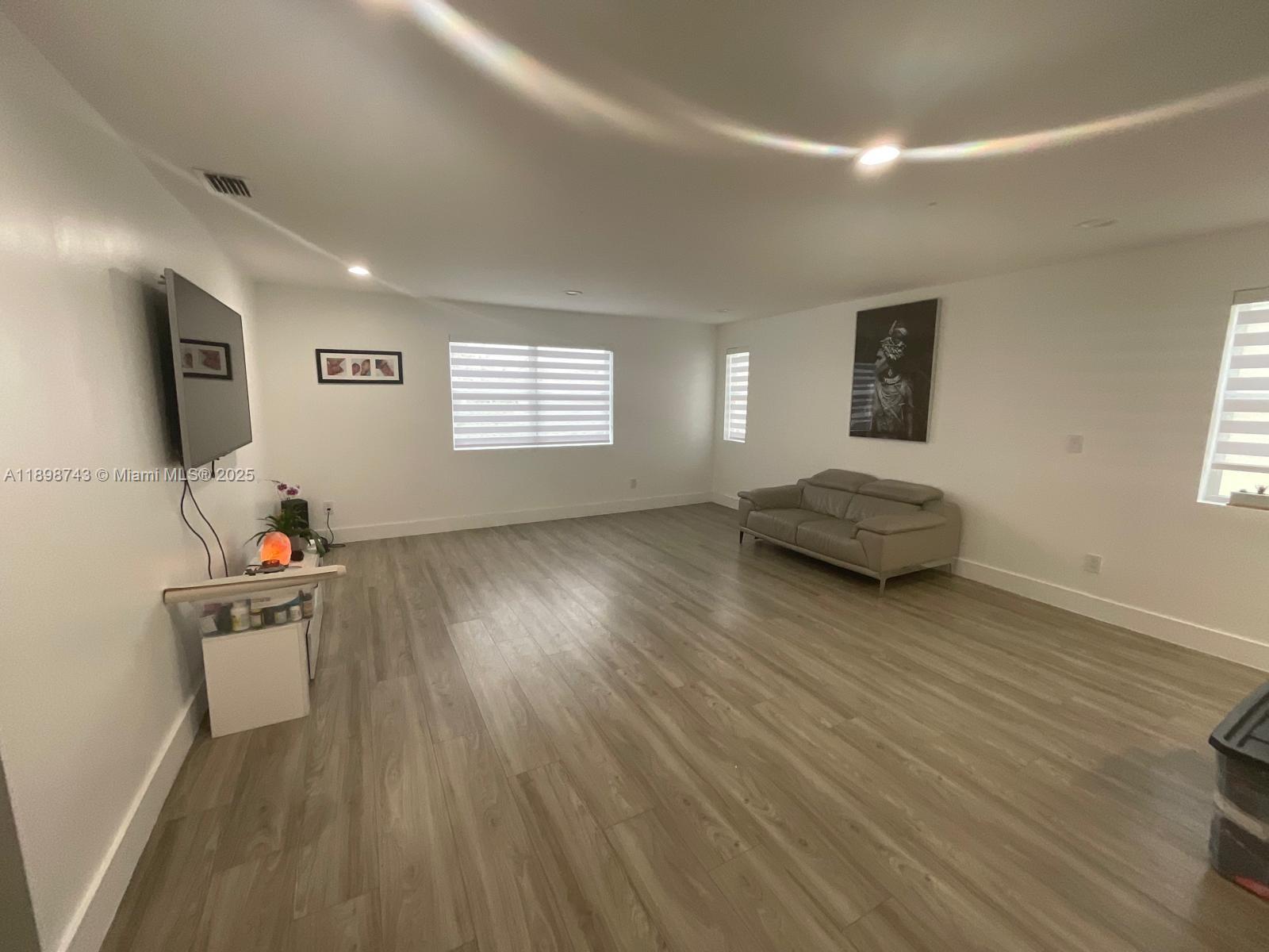 12100 Southwest 271st Street, Unit 12100 Homestead, FL 33032 - Photo 4 of 24 a living room with furniture and a wooden floor